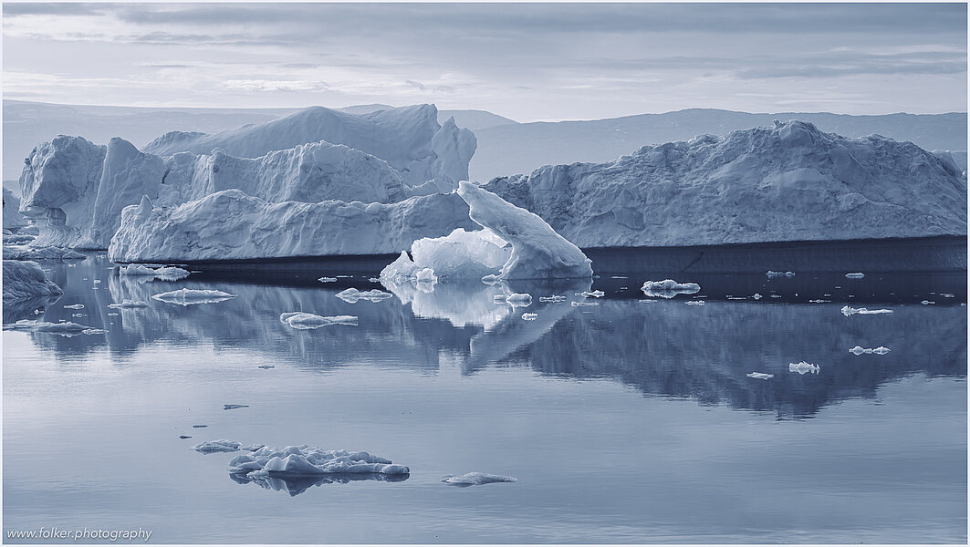 This fine-art photograph provides a beautiful view on icebergs at the Sermilik fjord in East-Greenland.