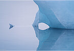 This fine-art photograph shows a minimalistic detail of an iceberg with refection in the water. Picture was taken at the Sermilik fjord in East-Greenland. 
