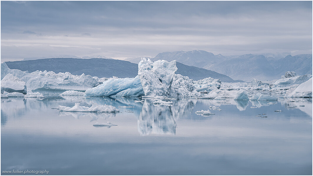 This fine-art photograph provides a beautiful view on icebergs at the Sermilik fjord in East-Greenland.