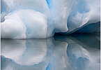 This fine-art photograph shows a minimalistic detail of an iceberg with reflection in the water. Nature created a beautiful abstract with cracks and layer of ice colors. Picture was taken at the Sermilik fjord in East-Greenland.
