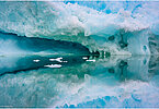 The backdrop of this fine-art photograph is formed and filled by a bigger iceberg with reflection in the water. Smaller elegantly shaped pieces of ice are passing in the foreground. Different shades of ice-blue color tones and cracks in the ice create a symmetric and well-balanced image that almost feels abstract. Picture was taken at the Sermilik fjord in East-Greenland.
