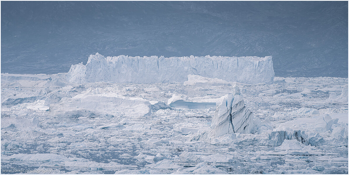 This fine-art photograph provides a beautiful view on icebergs at the Sermilik fjord in East-Greenland.