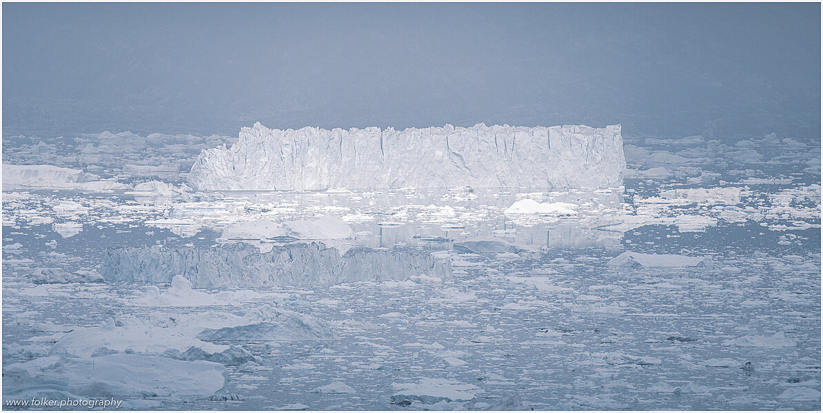 This fine-art photograph provides a beautiful view on icebergs at the Sermilik fjord in East-Greenland.
