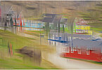 This fine-art photograph shows an abstract, painterly street scene in Tassilaq in East-Greenland. In a style of a painting from early 20th century, you can imagine colorful houses and a pathway 